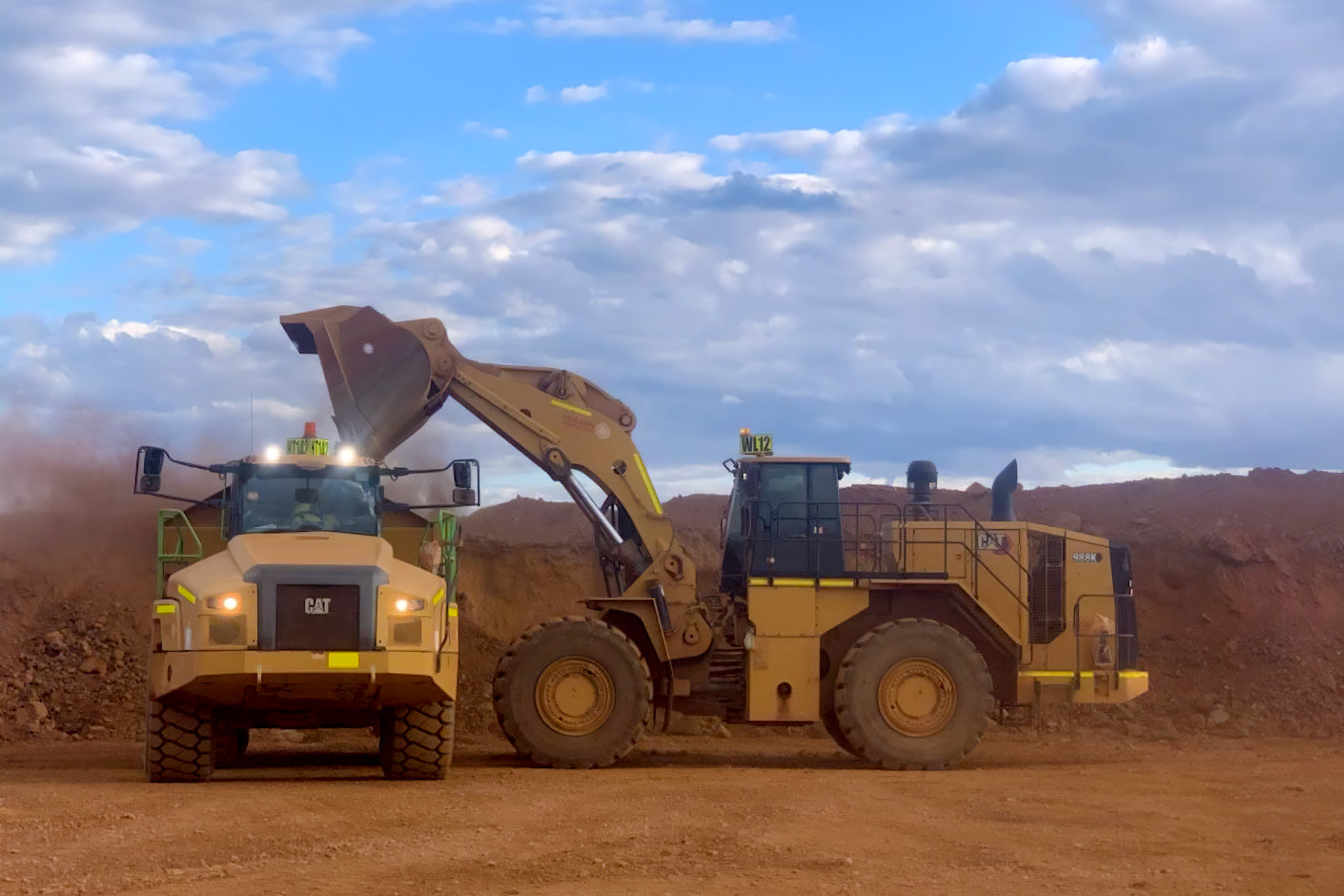 A bulldozer is filling up a mining truck